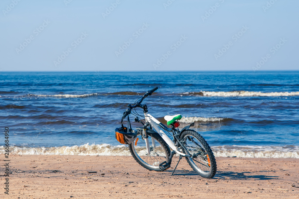 Fototapeta premium Bicycle parked on Baltic beach next to water in spring