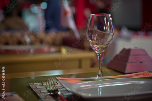 Empty wine glass. Tableware on table in cafe, focus on wineglass stem . Elegant table setting . Bakal