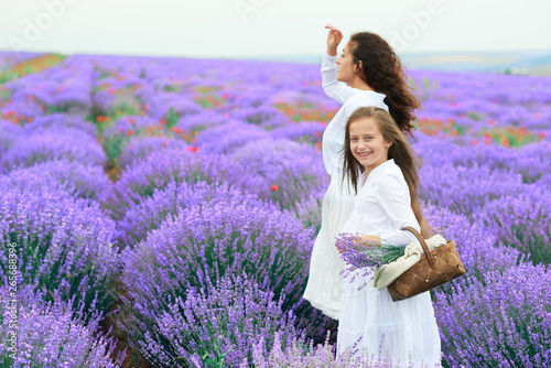 Fototapeta Naklejka Na Ścianę i Meble -  girls are in the lavender flower field, beautiful summer landscape