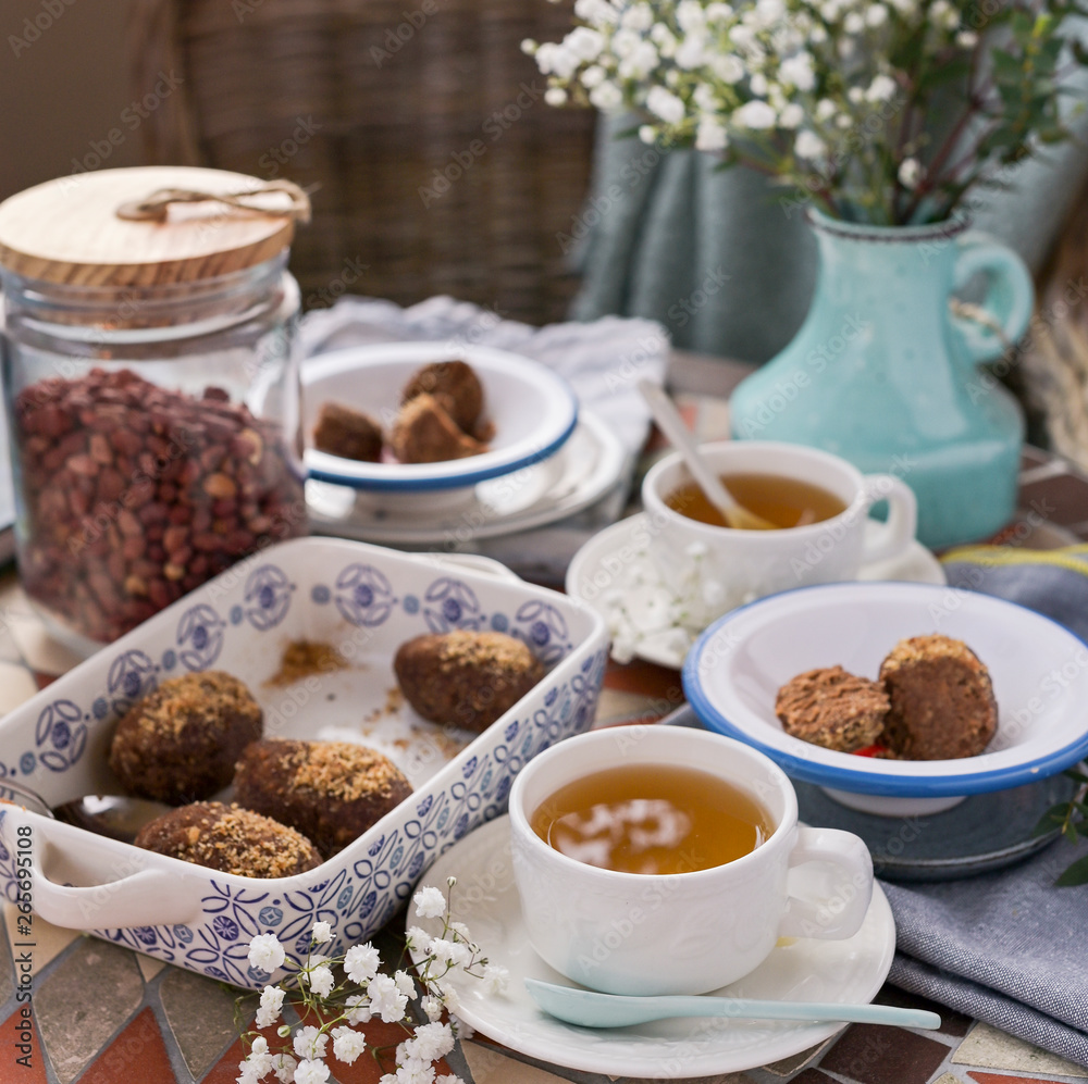 Traditional Russian cake with cocoa in the shape of a ball. Served breakfast table with mugs of tea and dessert. Traditional Russian cake with cocoa in the shape of a ball. Served breakfast table with mugs of tea and dessert.