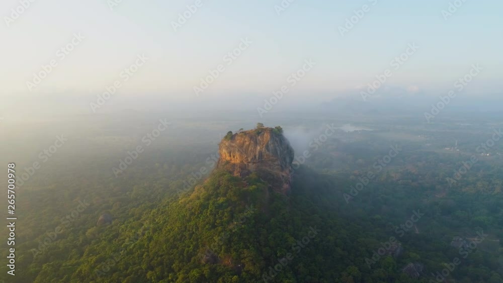 First light of sunrise over Sigiriya, the Lion Rock in Sri Lanka. Wide pan as morning mist covers valley First light of sunrise over Sigiriya, the Lion Rock in Sri Lanka. Wide pan as morning mist covers valley