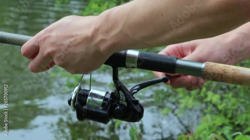the fisherman turns the coil on a fishing rod