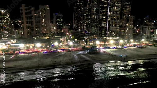Night aerial shot of a beach event with a stage and light show on the sand of Surfers Paradise Gold Coast Queensland Australia. A packed Cavill Ave can also been seen in background. photo