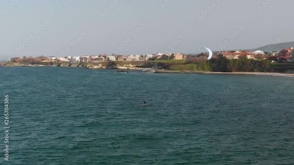 Aerial view of male surfer doing kiteboard in Lozenets village Black sea coast at daytime, Burgas, Bulgaria. Panning right shot. Aerial view of male surfer doing kiteboard in Lozenets village Black sea coast at daytime, Burgas, Bulgaria. Panning right shot.