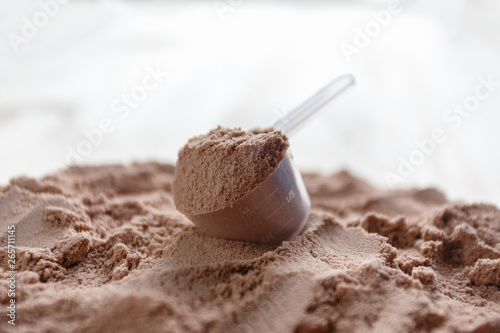 Wallpaper Mural Product photograph of spoon or measuring scoop of whey protein. Whey protein powder sports bodybuilding supplement. Plastic scoop on wooden background with chocolate powder flavour. Torontodigital.ca
