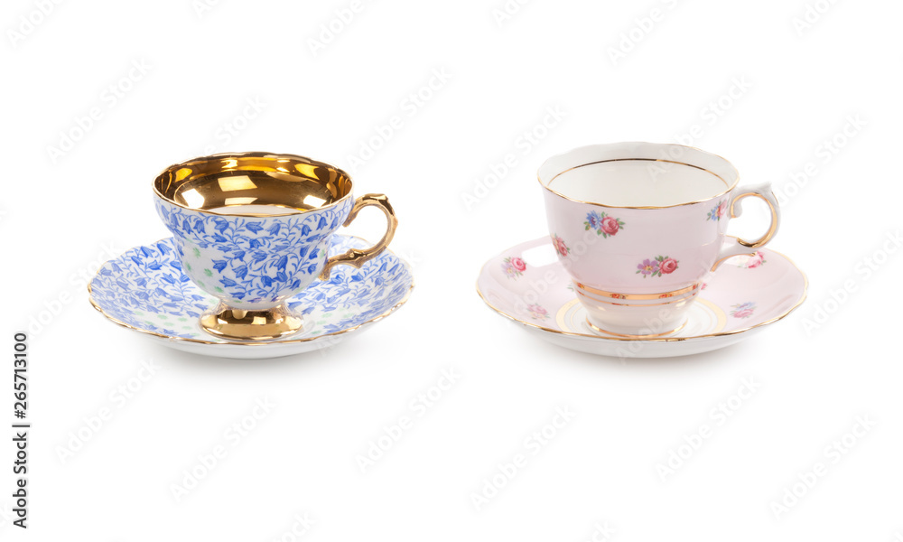 High resolution close-up of two beautiful antique tea cups with saucers isolated on a white background. High resolution close-up of two beautiful antique tea cups with saucers isolated on a white background.