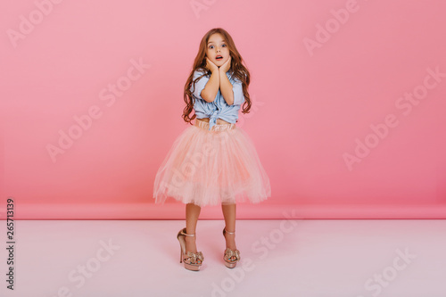 Εκτύπωση καμβά Lovely moments of cute little astonished girl expressing to camera isolated on pink background