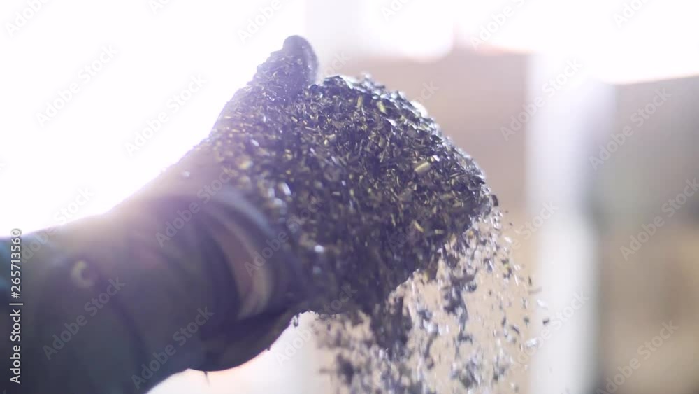 Metal flakes fall from a gloved hand