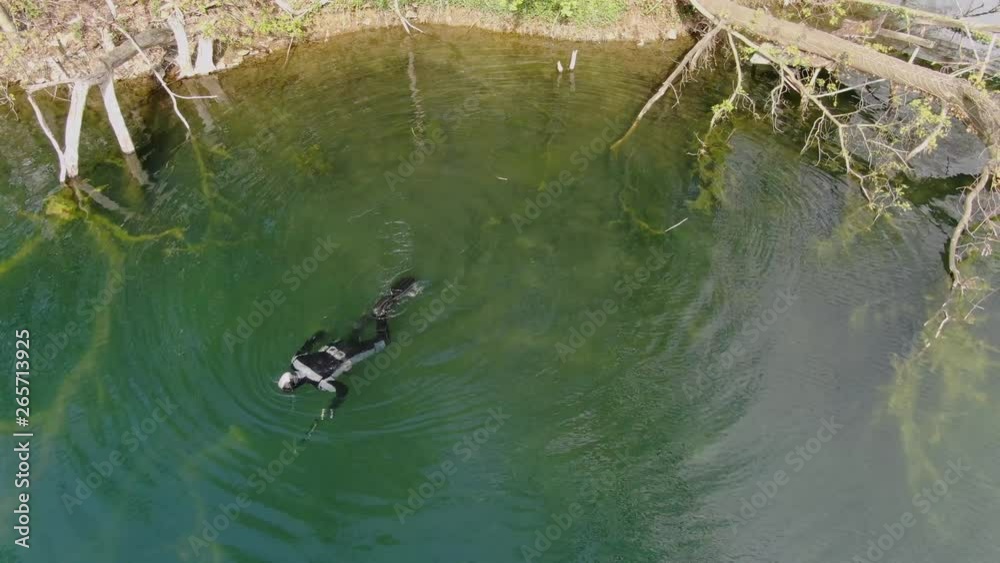 Male in snorkeling mask dive underwater and hunting fish on the lake