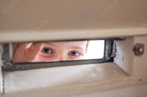 Girl peeping through the letter box