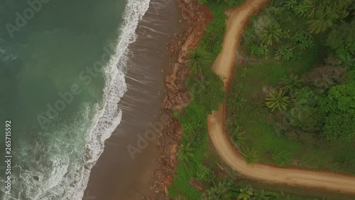 Aerial view of interesting dirt road between big ocean waves and central american jungle photo