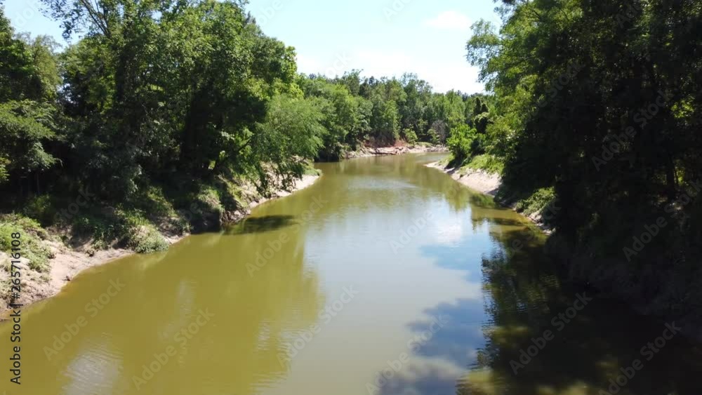 Camera pan over a low muddy river on a trail. Camera pan over a low muddy river on a trail.