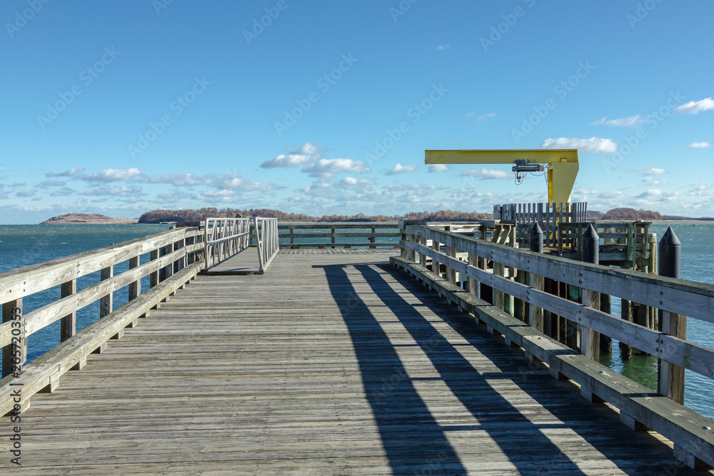 Fototapeta premium Old wooden pier with fencing leading out to bay