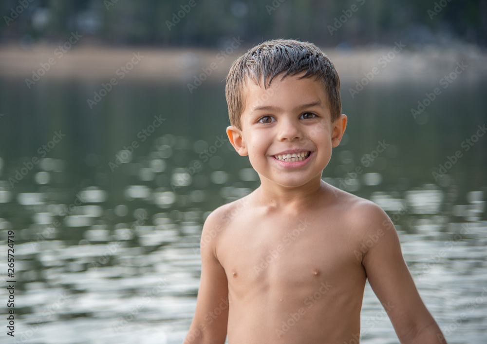 Fototapeta premium Smiling shirtless little boy swimming in mountain lake