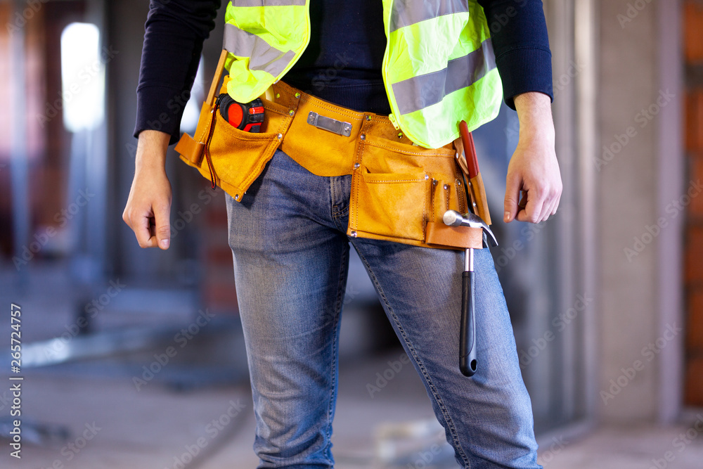 worker wearing belt with tools on a construction site worker wearing belt with tools on a construction site
