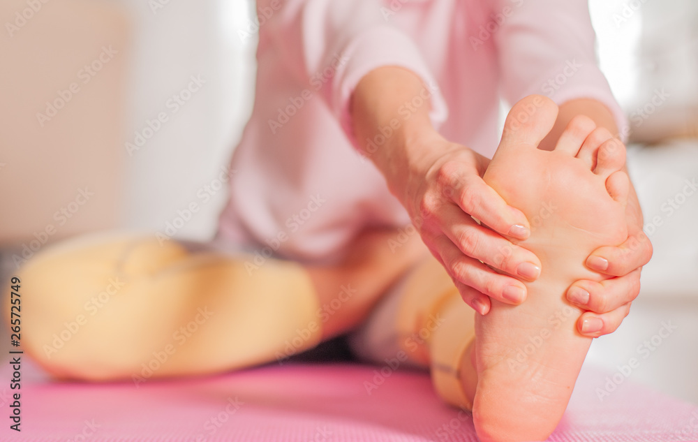 Woman practicing yoga, sitting in head to knee forward bend exercise, Janu Sirsasana pose Woman practicing yoga, sitting in head to knee forward bend exercise, Janu Sirsasana pose