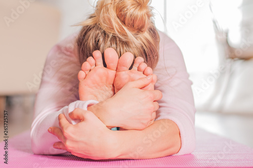 Woman practicing yoga, seated forward bend pose, doing paschimottanasana exercise
