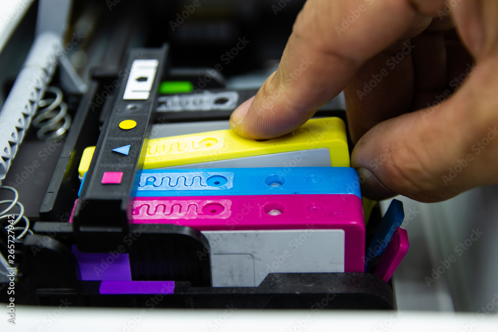 Close up hand man put the color printer ink jet cartridge of the printer inject 