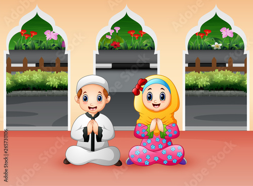 Muslim boy and girl are praying at Mosque
