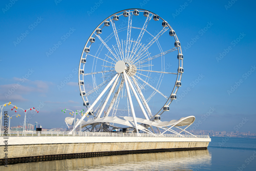 Tourist attraction - a ferris wheel on the shore of the Caspian Sea on a sunny December afternoon. Baku, Azerbaijan