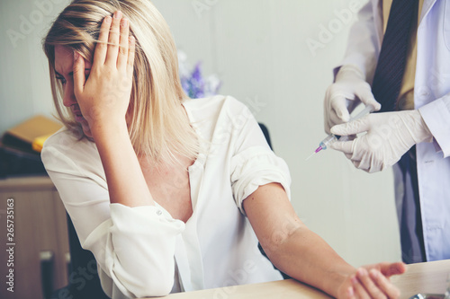 Foto Nurse hand with syringe needle and woman fear of injections phobia concept again