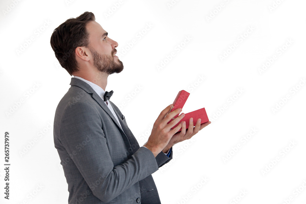 Man standing and holding red gift box behind his back Man standing and holding red gift box behind his back