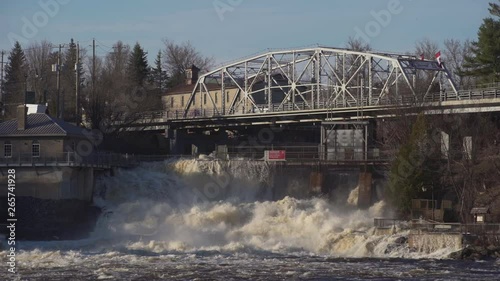 Wide shot of flood waters pouring over a dam in Bracebridge, Ontario photo