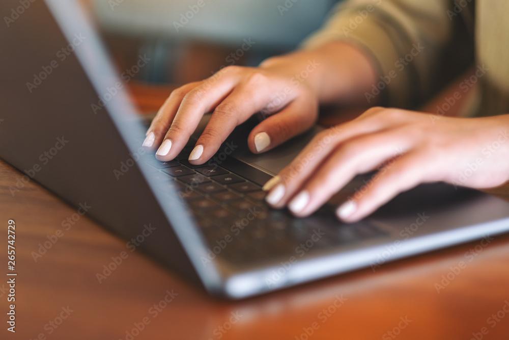 Closeup image of woman's hands using and typing on laptop computer keyboard Closeup image of woman's hands using and typing on laptop computer keyboard
