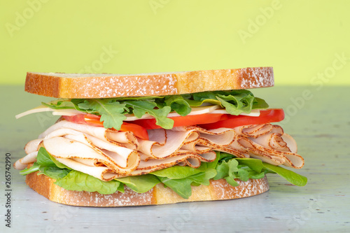 Fresh big sandwich. Turkey ham on a white bread with lettuce, tomatoes and cheese. Food background. photo