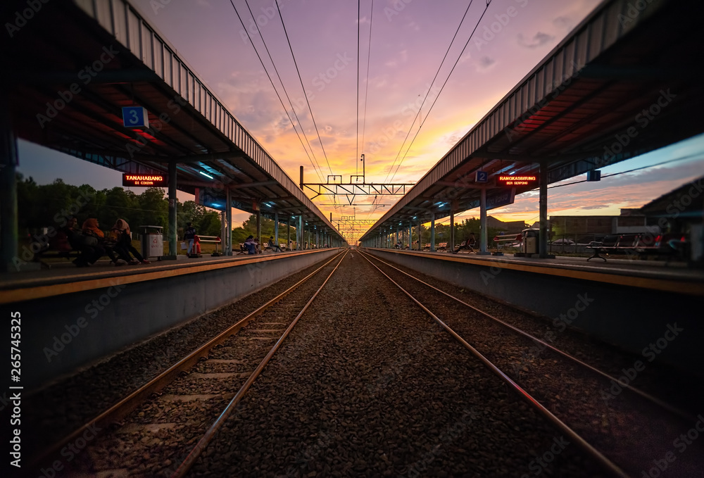 Tigaraksa KRL Commuter Line Train Station at Sunset with Two Line of Railroad or Railway.