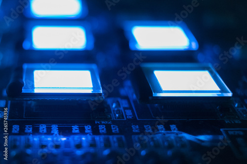 The process of checking several oled displays on the test station. Displays glow brightly blue color close up. photo