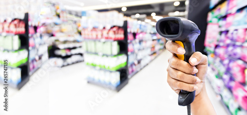 Barcode Reader at hand and background blur of the supermarket In the form of design banner,panoramic for panoramic banner background with copy space