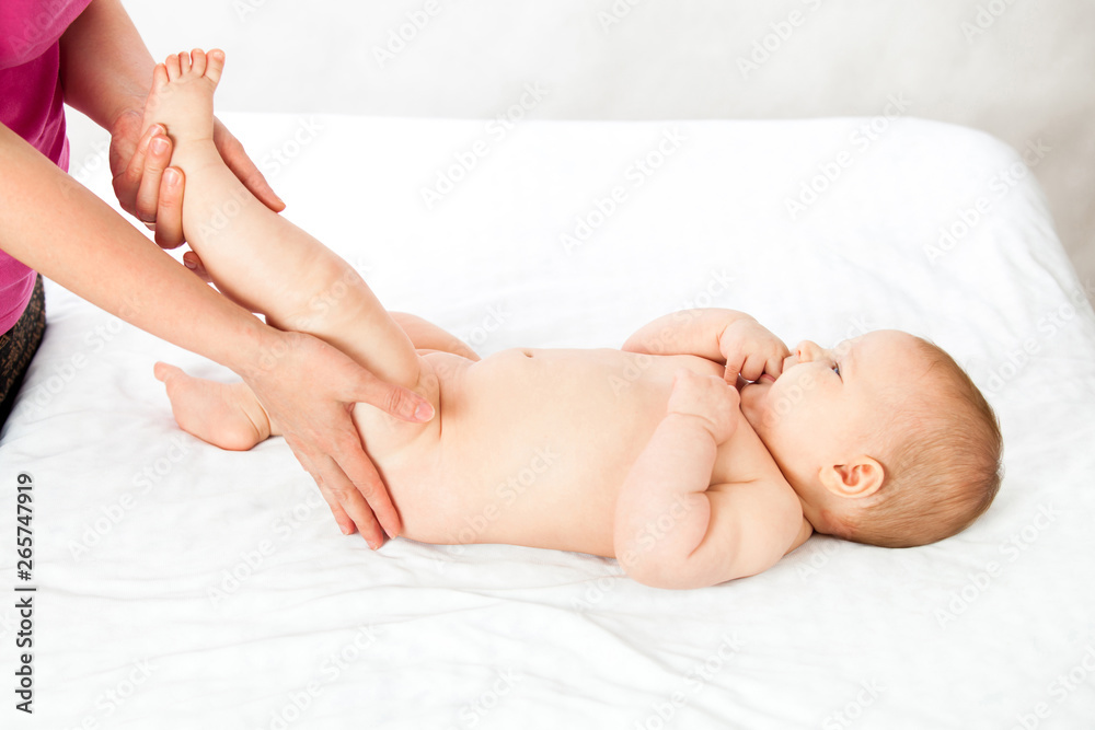 baby loves the massage the leg muscles. masseuse doing massage to the baby. child on white isolated background. baby loves the massage the leg muscles. masseuse doing massage to the baby. child on white isolated background.