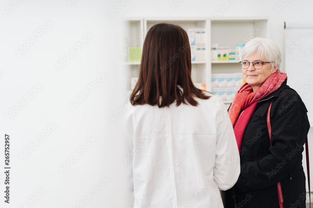Fototapeta premium Elderly woman being attended to in a pharmacy