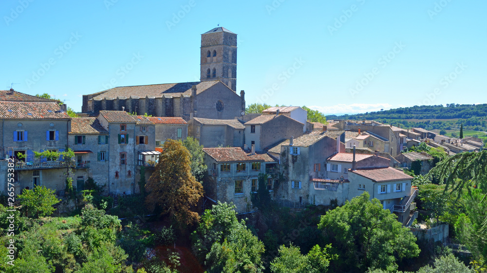 A view of the village of Montolieu Aude  Languedoc - Roussillon  France. Trees valley ancient houses and church bell tower.