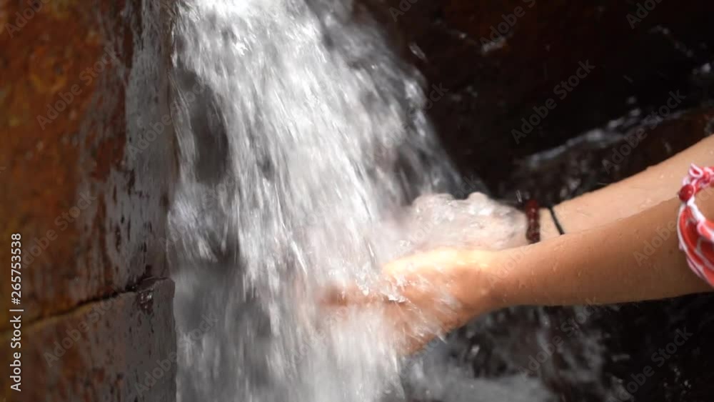 Woman hands under the water of a waterfall in the mountains. Cupped female hands gathering fresh clean source water, close up, slow motion Woman hands under the water of a waterfall in the mountains. Cupped female hands gathering fresh clean source water, close up, slow motion