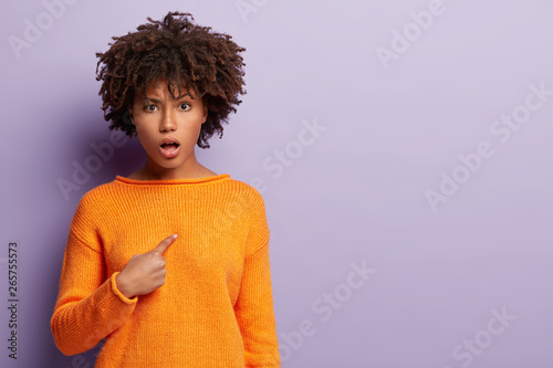Fotografia Dissatisfied woman points at herself indignantly, looks angrily at camera, disco