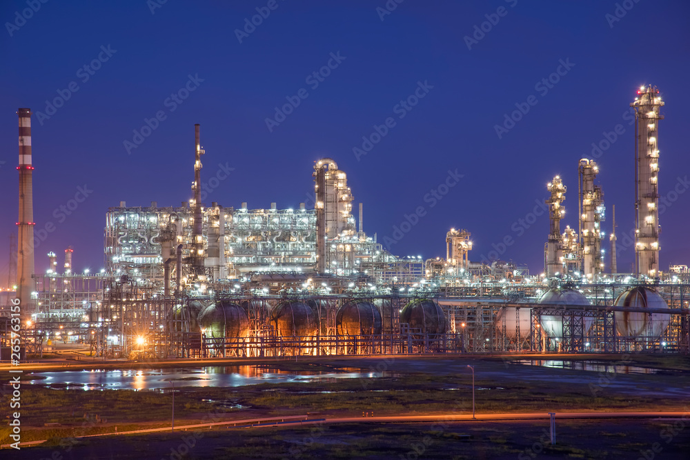 Fototapeta premium Oil refineries and oil depots and close-up of pipelines and destillation tanks of an oil-refinery plant in the evening