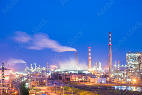 Oil refineries and oil depots and close-up of pipelines and destillation tanks of an oil-refinery plant in the evening