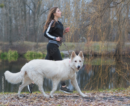 Young girl with dog running at the forest