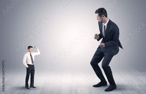 Big debutant young businessman scared of small strong businessman 