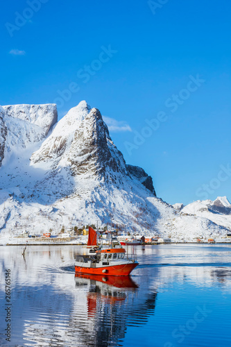 Fishing boat approaches the shore after a working day, a beautiful sea bay