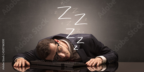Photos Young businessman fell asleep at the table on his keyboard concept