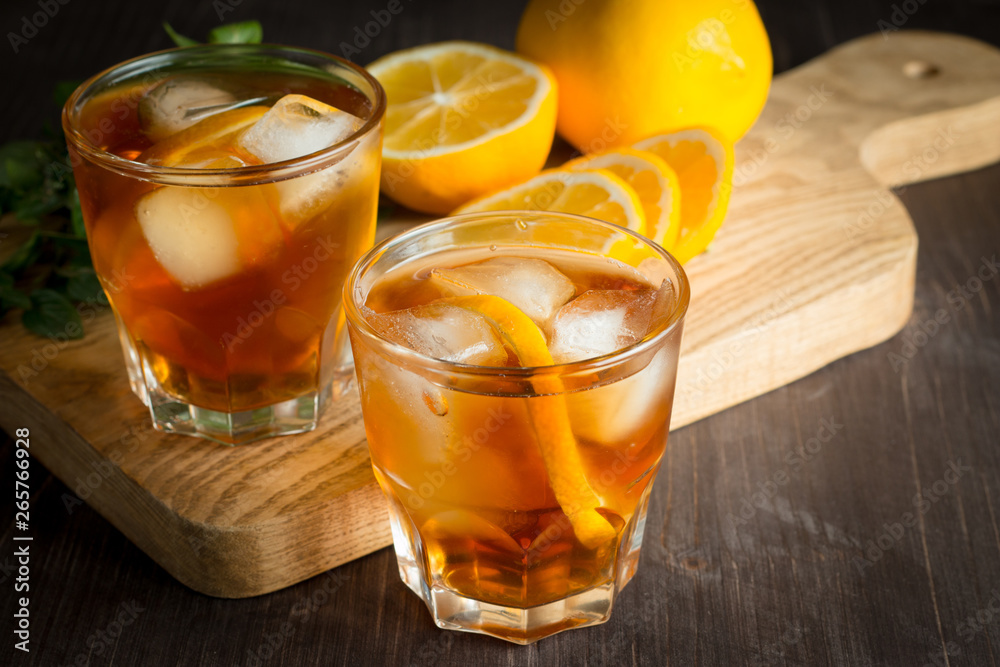 Glasses of cold ice tea with lemon, ice, mint on background. Homemade lemonade. Spring and summer drinks and beverages concept. Glasses of cold ice tea with lemon, ice, mint on background. Homemade lemonade. Spring and summer drinks and beverages concept.