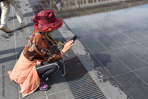 amateur photographer with mobile  in  a  red hat in the process of organising the frame 