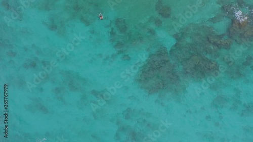 Aerial cenital shot of a panga boat and a tourist swimming in the Marietas Islands, Nayarit, Mexico photo