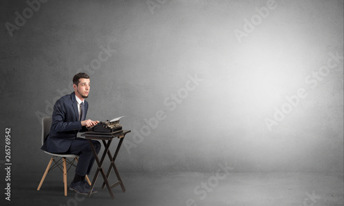 Man working hard on a typewriter in an empty space 