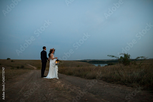 the bride and groom walk at sunset.