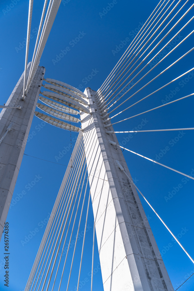 Detail of a white suspension bridge on a clear blue sky Detail of a white suspension bridge on a clear blue sky