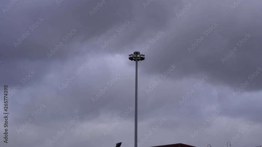 The Storm is approaching, a light pole in the middle of the frame is shaking from the intense wind. The Storm is approaching, a light pole in the middle of the frame is shaking from the intense wind.